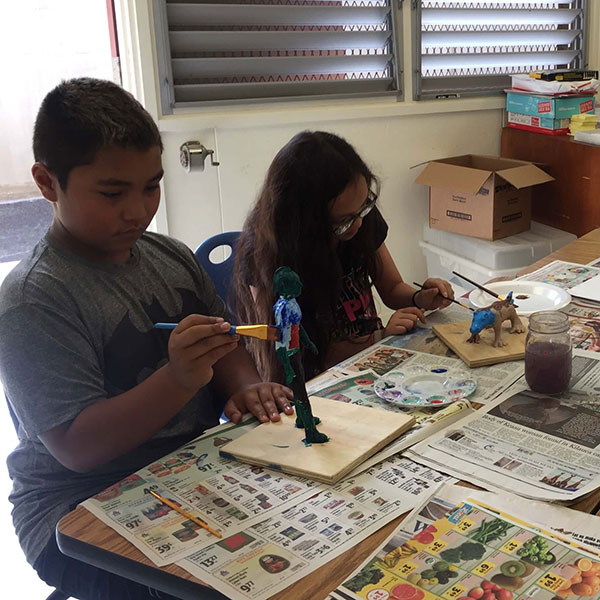 children painting sculptures